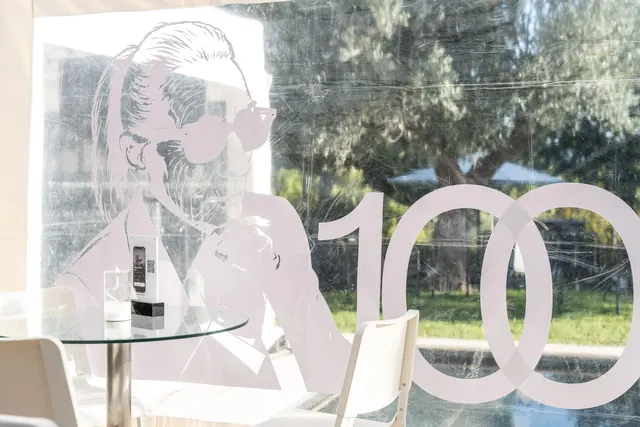 Party decor: a large “100” and Mémé's silhouette in sunglasses, in black and white