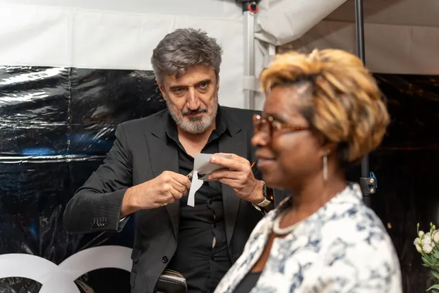 Igor Kucinic cuts a guest's silhouette portrait live as she watches her profile appear