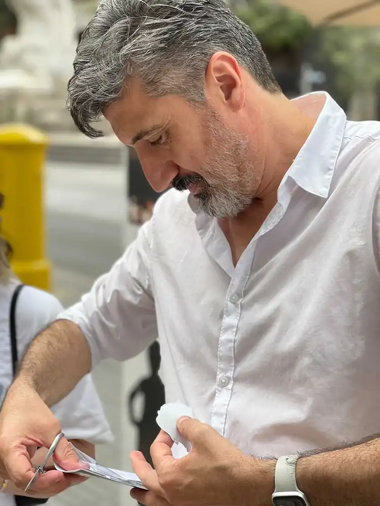 Igor Kucinic cutting a silhouette portrait from a folded sheet of paper