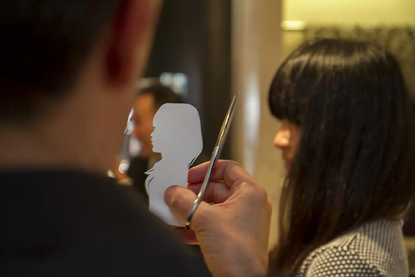 Igor Kucinic hand-cutting a silhouette portrait live at a Dior event