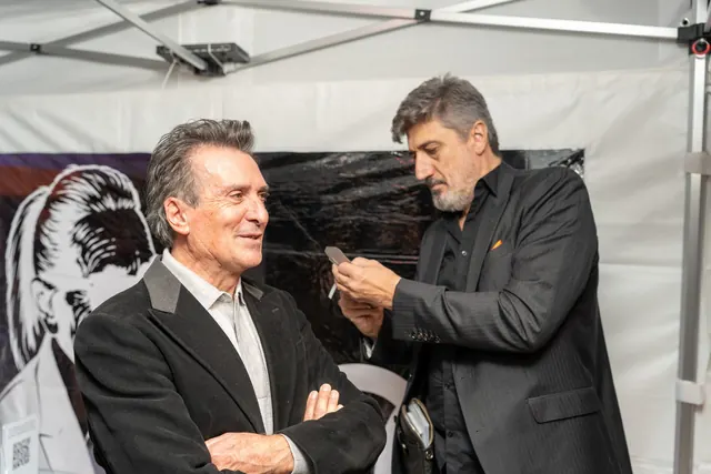 Igor Kucinic, silhouette artist, hand-cuts a guest's profile portrait with scissors under the marquee at the 100th birthday party