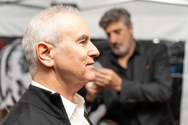 A guest holds his profile while Igor Kucinic cuts his silhouette with scissors, live